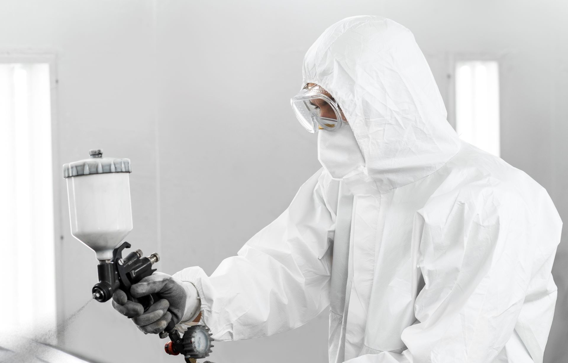 man-hazmat-suit-using-gun-paint-car-shop